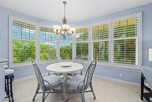 dining room with a chandelier, baseboards, and light tile patterned flooring