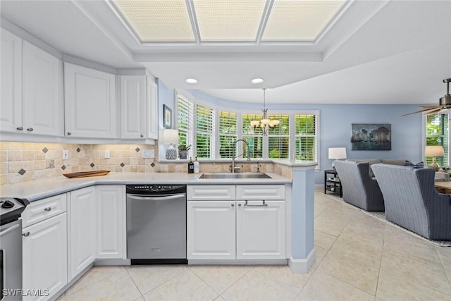 kitchen featuring tasteful backsplash, open floor plan, light countertops, appliances with stainless steel finishes, and a sink