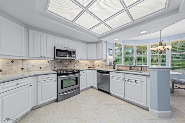 kitchen featuring light tile patterned flooring, decorative backsplash, stainless steel appliances, and a sink