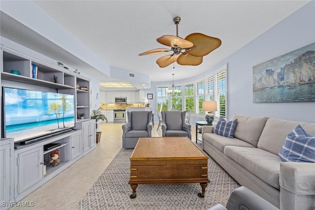 living area featuring light tile patterned floors and ceiling fan with notable chandelier