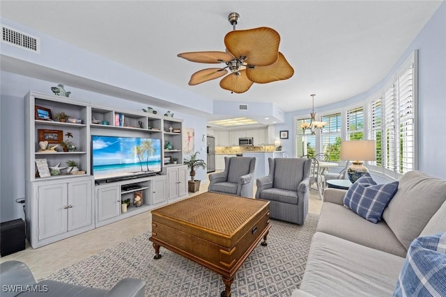 living room with visible vents and ceiling fan with notable chandelier