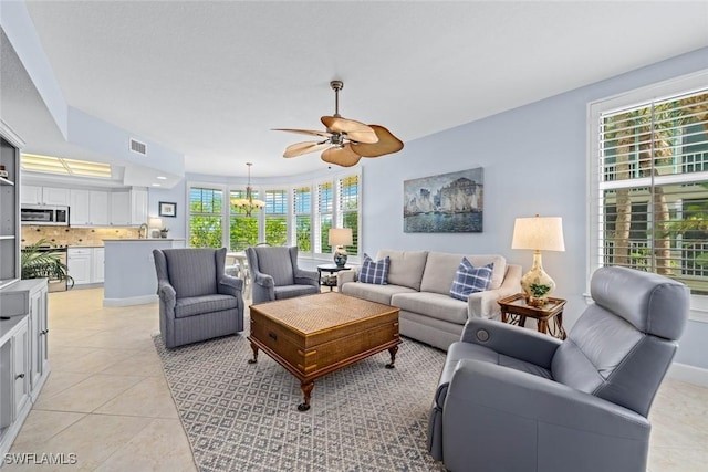 living area with visible vents, baseboards, light tile patterned flooring, and ceiling fan with notable chandelier