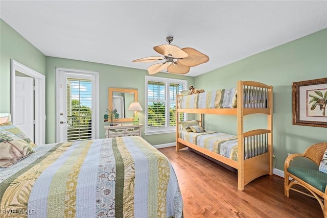 bedroom with baseboards, wood finished floors, a ceiling fan, and access to outside