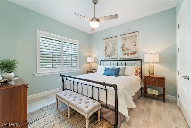 bedroom featuring light wood-type flooring, a ceiling fan, and baseboards