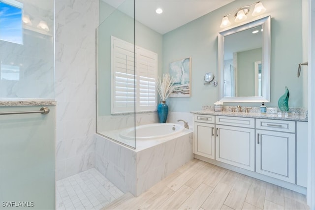 bathroom with vanity, walk in shower, and a bath