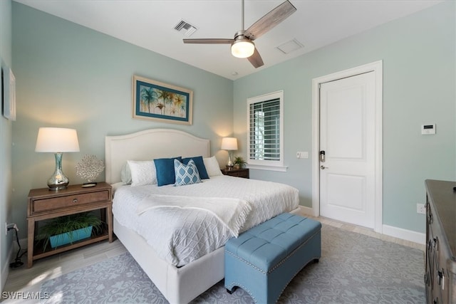 bedroom featuring ceiling fan, wood finished floors, visible vents, and baseboards