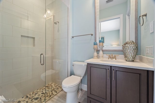 bathroom featuring visible vents, a stall shower, vanity, and toilet