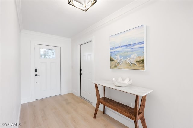 entrance foyer with light wood-style flooring, baseboards, and crown molding