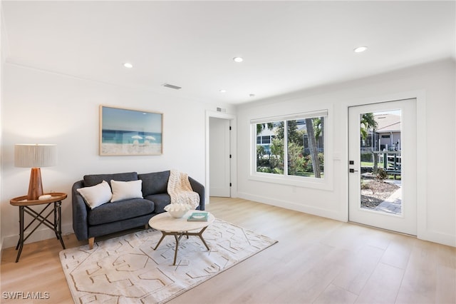 living area with light wood-type flooring, visible vents, and recessed lighting