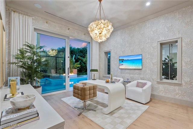 living room featuring baseboards, a chandelier, wood finished floors, and wallpapered walls