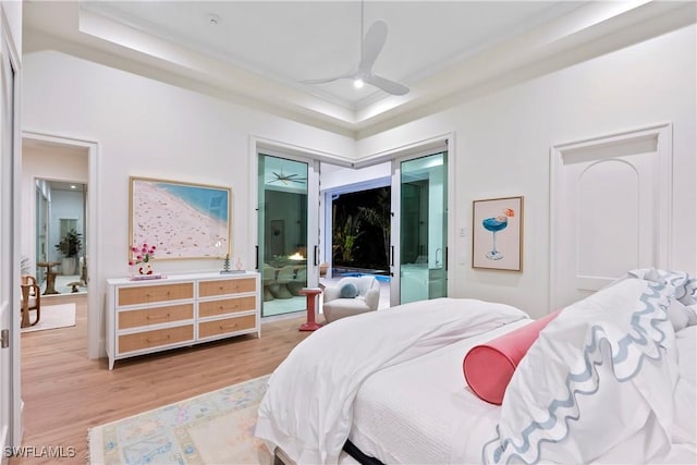 bedroom featuring light wood-type flooring and a tray ceiling