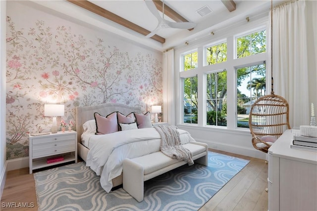 bedroom with beamed ceiling, baseboards, and wallpapered walls