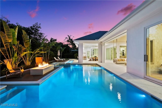 outdoor pool featuring a patio area and a fire pit