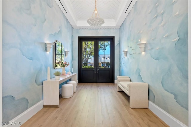 foyer entrance with french doors, crown molding, baseboards, and wood finished floors