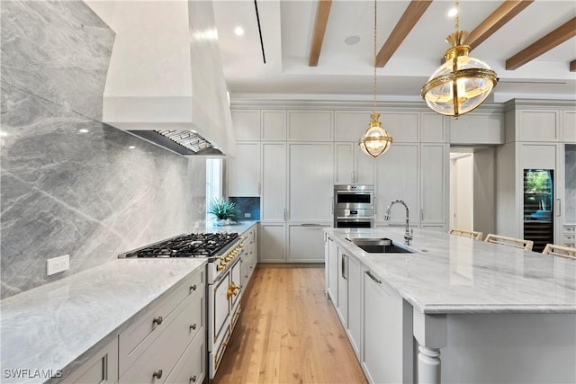 kitchen featuring a sink, light stone countertops, tasteful backsplash, beamed ceiling, and custom range hood