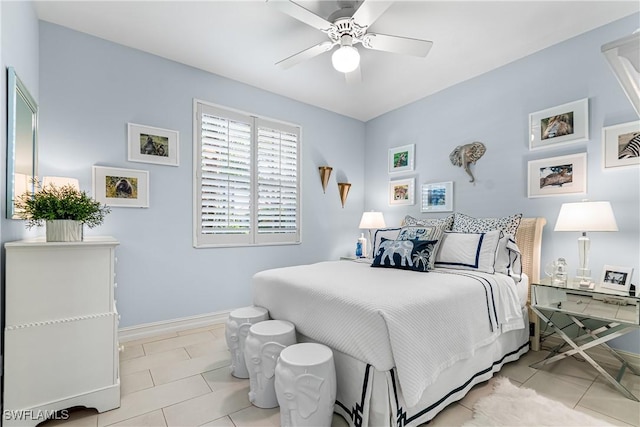 tiled bedroom with a ceiling fan and baseboards