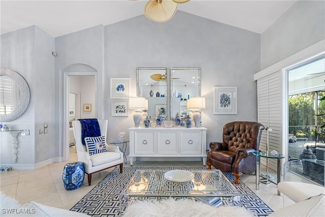 sitting room featuring light tile patterned floors, baseboards, arched walkways, and high vaulted ceiling