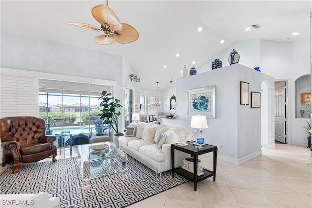 living area featuring arched walkways, visible vents, high vaulted ceiling, and light tile patterned flooring