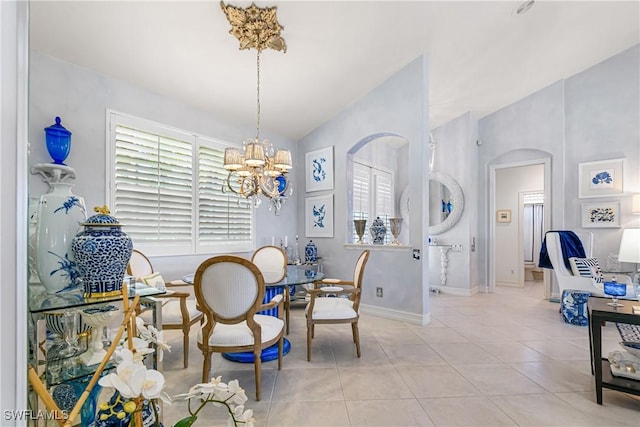 dining space featuring arched walkways, a chandelier, light tile patterned flooring, and vaulted ceiling