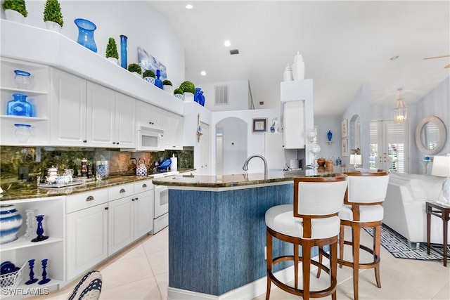 kitchen with arched walkways, white cabinets, white appliances, and open shelves