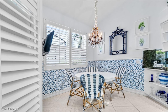 dining room with a wainscoted wall, a notable chandelier, breakfast area, tile walls, and tile patterned flooring