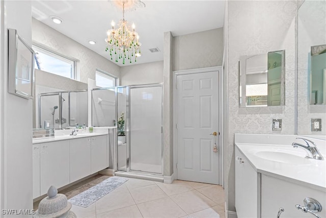 bathroom with two vanities, a sink, a shower stall, tile patterned flooring, and a chandelier