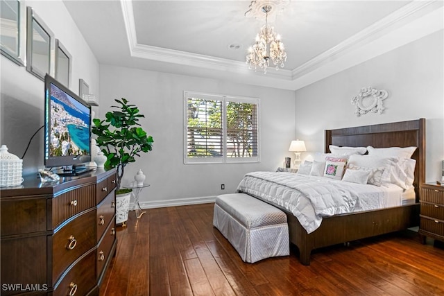 bedroom featuring a tray ceiling, wood-type flooring, a notable chandelier, and baseboards