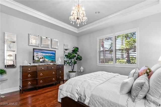 bedroom with baseboards, dark wood finished floors, ornamental molding, a notable chandelier, and a raised ceiling