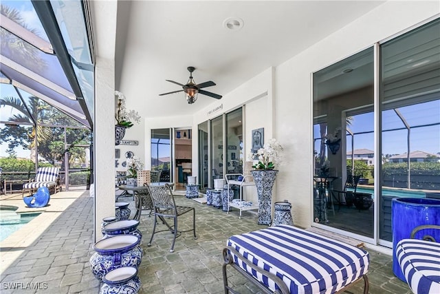 view of patio featuring a lanai, a ceiling fan, and an outdoor pool