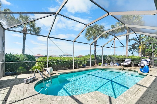 pool with glass enclosure and a patio area