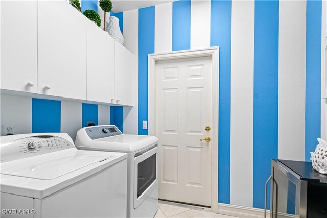 laundry area with cabinet space, light tile patterned floors, independent washer and dryer, and baseboards