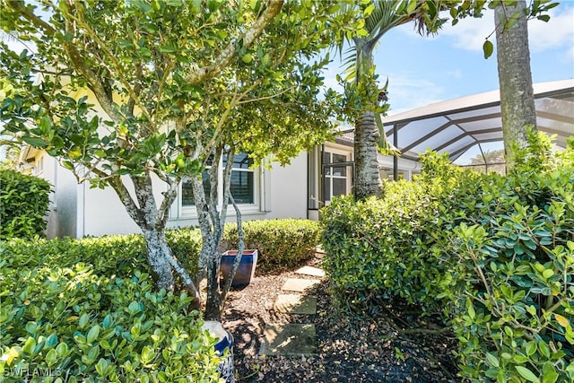 view of side of home featuring stucco siding and a lanai