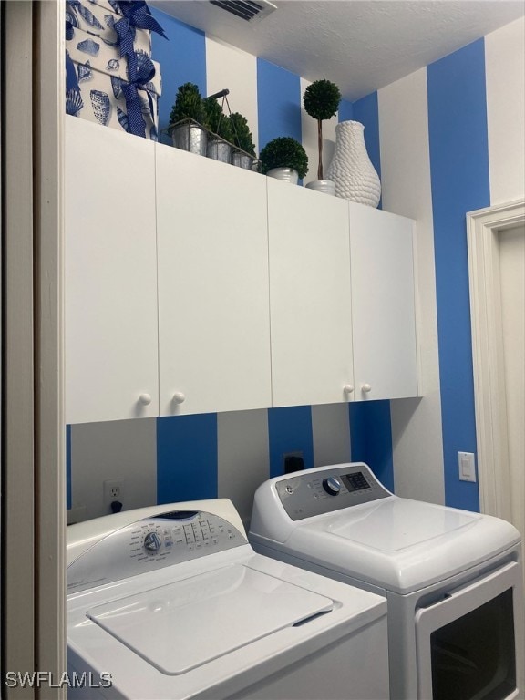 laundry area featuring visible vents, cabinet space, and independent washer and dryer