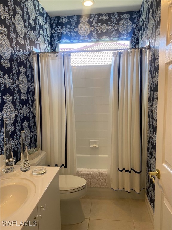 bathroom with toilet, shower / bath combo, tile patterned flooring, wallpapered walls, and vanity