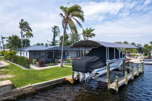 dock area with a lawn, a water view, boat lift, and a lanai