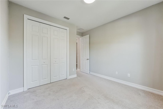 unfurnished bedroom with a closet, visible vents, baseboards, and carpet flooring