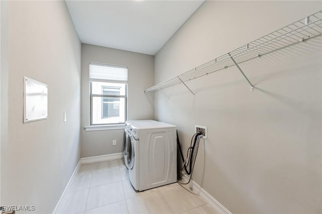 clothes washing area with washer hookup, laundry area, baseboards, and light tile patterned floors