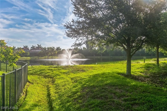 view of yard featuring a water view and fence