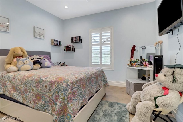 bedroom with recessed lighting, wood finished floors, and baseboards