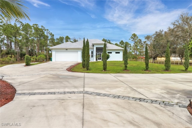 view of front facade with an attached garage, driveway, a front lawn, and stucco siding