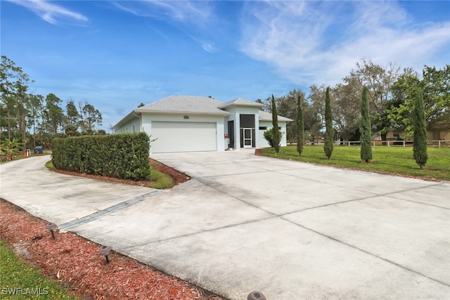 view of front of house with an attached garage, stucco siding, driveway, and a front yard