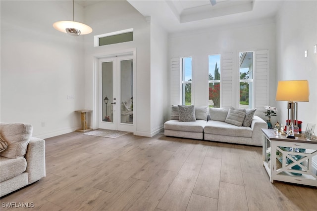 living area featuring baseboards, wood finished floors, and french doors