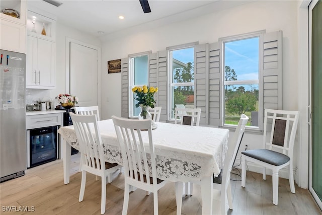 dining space with a wealth of natural light, wine cooler, light wood-style flooring, and recessed lighting