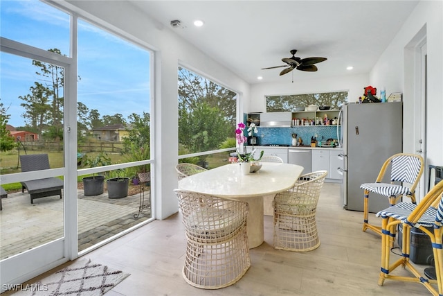 sunroom / solarium featuring ceiling fan