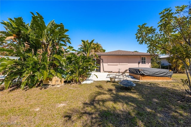 view of yard featuring a covered hot tub and a patio