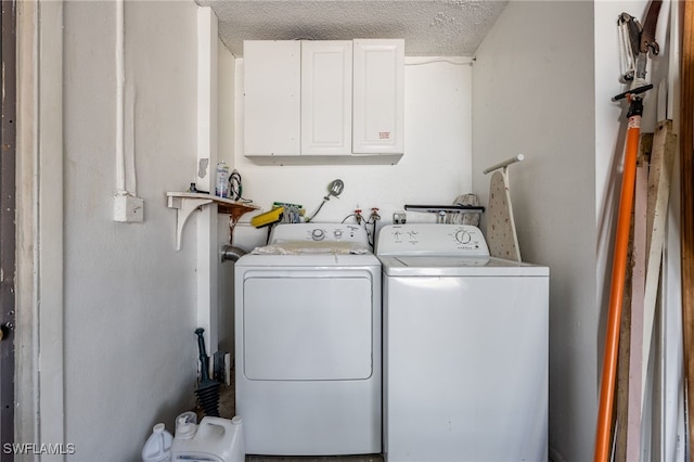 laundry room featuring a textured ceiling, cabinet space, and washer and dryer