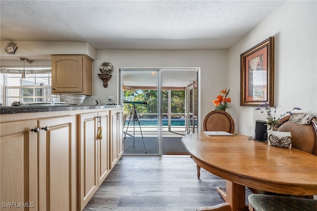 kitchen with a textured ceiling, wood finished floors, and light brown cabinets