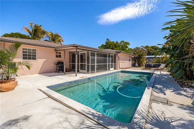 pool with a patio area, a sunroom, and area for grilling