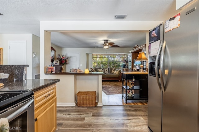 kitchen featuring visible vents, dark wood finished floors, ceiling fan, stainless steel appliances, and a textured ceiling