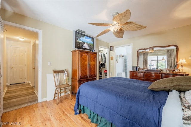 bedroom featuring baseboards, visible vents, ceiling fan, a spacious closet, and light wood-type flooring